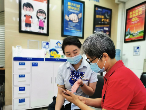 建行成都第六支行，大堂經(jīng)理為客戶介紹手機(jī)銀行“大字”模式
